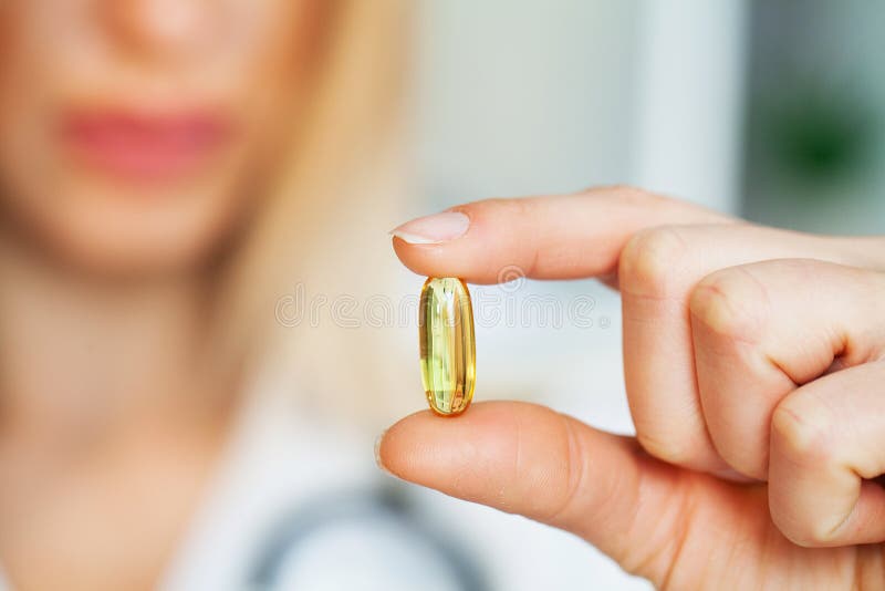 Sluiting van de vrouwelijke arts die de pil vasthoudt stock afbeeldingen