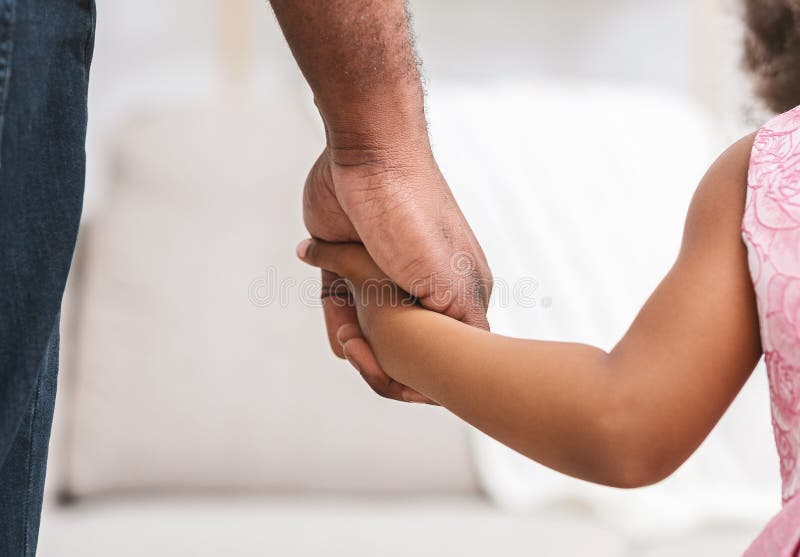 Black father giving hand to his little daughter, close up, supporting, care, parenthood concept. Black father giving hand to his little daughter, close up, supporting, care, parenthood concept