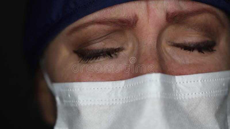 Sluiting van een pijnlijke tragische arts of verpleegster met een medisch gezichtsmasker