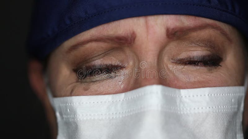 Sluiting van een pijnlijke tragische arts of verpleegster met een medisch gezichtsmasker