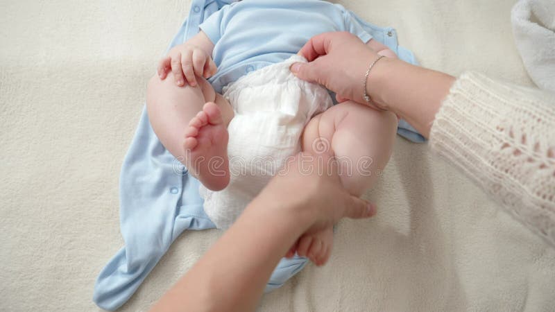 Sluiting van kleedluiers en kledij van kleine babyjongen op bed. concept van ouderschapshygiëne en kinderverzorging