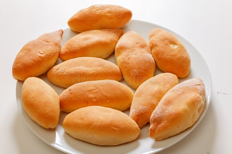 Sluiting, zelfgemaakte keuken Kleine pasteien liggen op een wit bord stock afbeelding Sluiting, zelfgemaakte keuken Kleine pasteien liggen op een wit bord stock afbeelding