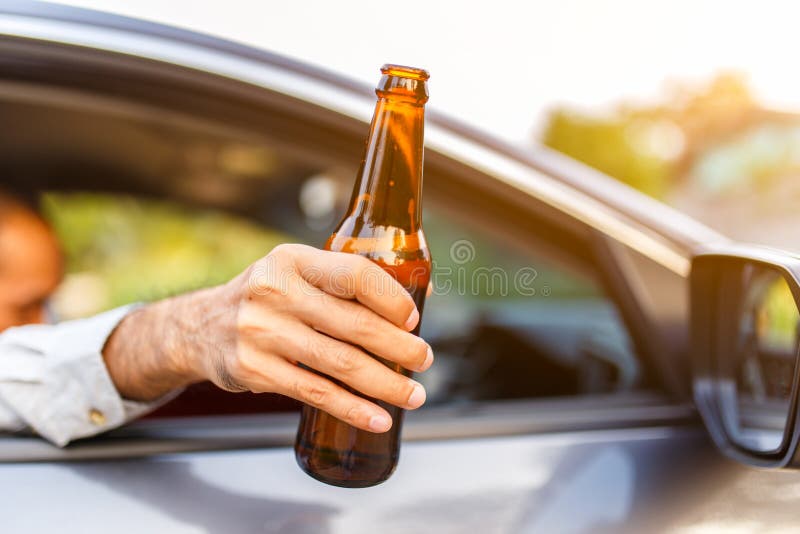 Slut på flaskan med öl med solnedgång, farligt körkoncept
