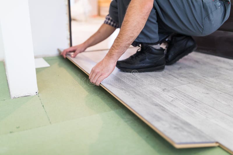 Slut upp arbetaren för manhandsnickare som installerar laminatdurken i det nya rummet royaltyfria foton Slut upp arbetaren för manhandsnickare som installerar laminatdurken i det nya rummet royaltyfria foton