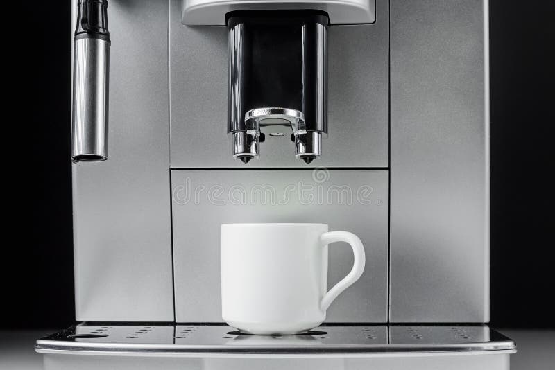 Slut upp av den moderna kaffemaskinen och vitkoppen på svart bakgrund fotografering för bildbyråer Slut upp av den moderna kaffemaskinen och vitkoppen på svart bakgrund fotografering för bildbyråer