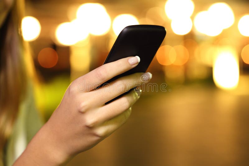 Slut upp av en kvinnahand genom att använda en smart telefon i natten