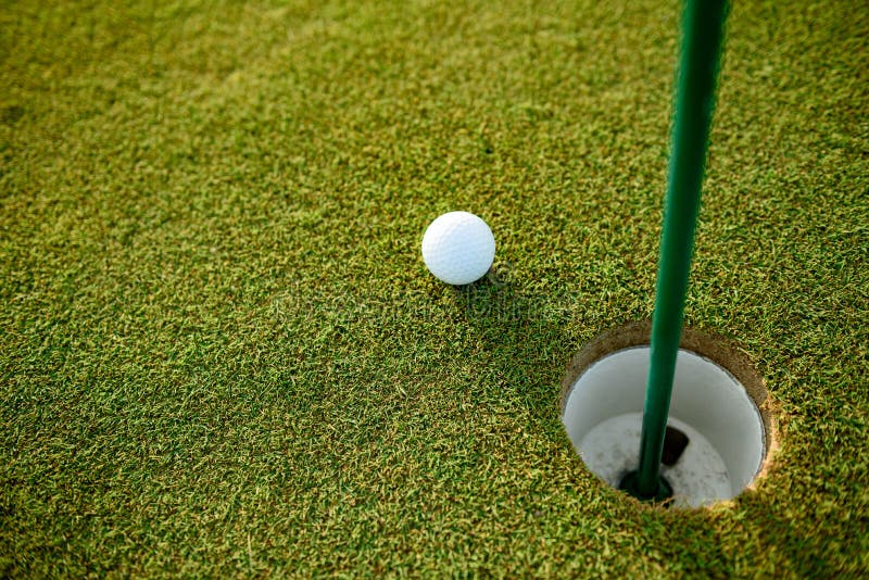 Slut upp av golfboll bredvid hålet arkivfoto Slut upp av golfboll bredvid hålet arkivfoto