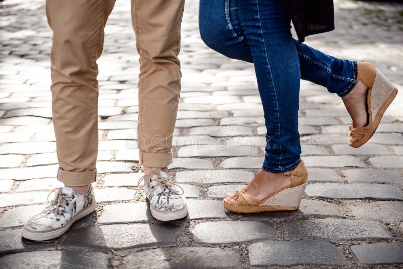 Slut upp av pars ben i keds som står på gatan arkivbilder Slut upp av pars ben i keds som står på gatan arkivbilder