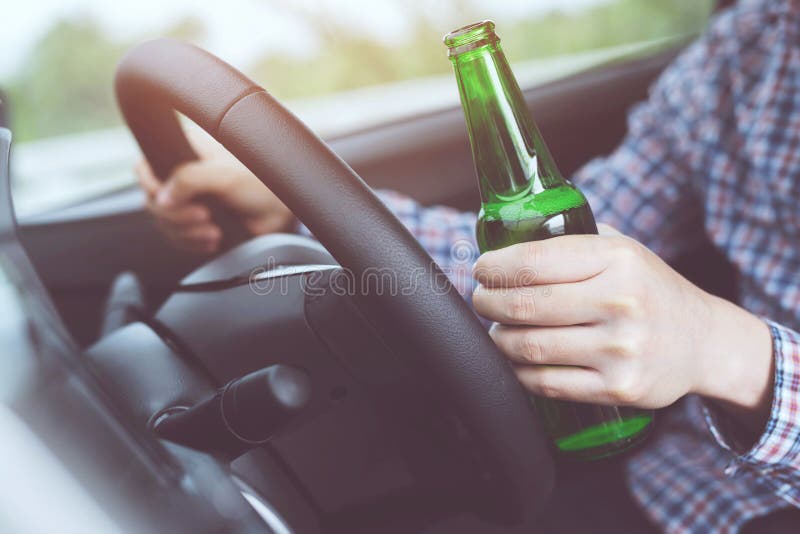 Slut upp berusad ung man för hand, medan köra en bil med en flaska av öl Drink f?r universitetsl?rare` t och drevbegrepp k?rning