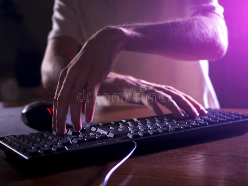 Slut upp gamerhänder på tangentbordet som spelar videospel i natt arkivbilder Slut upp gamerhänder på tangentbordet som spelar videospel i natt arkivbilder