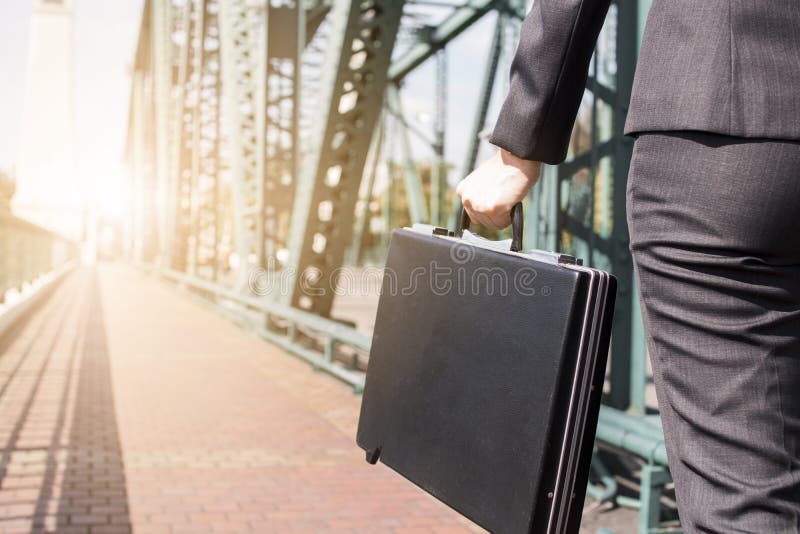 Close up business woman holding black briefcase on the metal bridge walking to work, go to target and goal concept. Close up business woman holding black briefcase on the metal bridge walking to work, go to target and goal concept