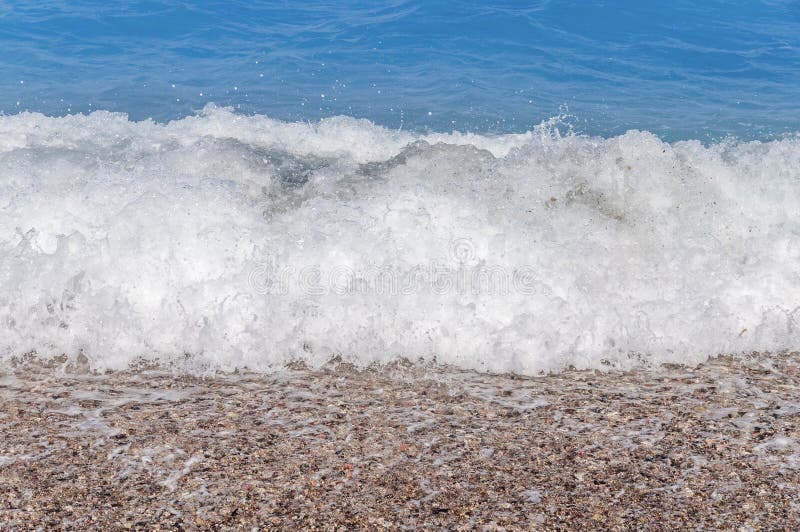 Slut upp stor blå havsvattenvåg på sandstranden med bubblor arkivbilder Slut upp stor blå havsvattenvåg på sandstranden med bubblor arkivbilder