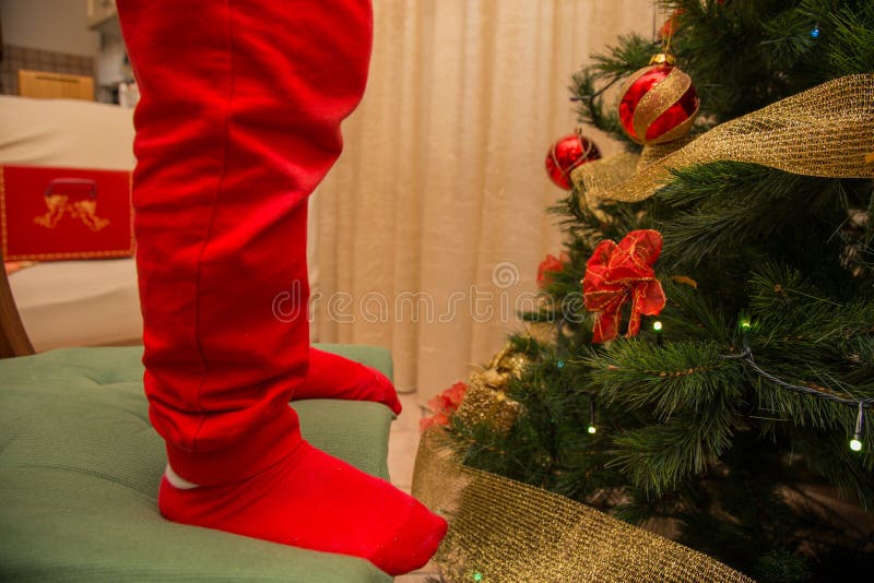 Close up baby on chair with red stockings near christmas tree with background. Close up baby on chair with red stockings near christmas tree with background