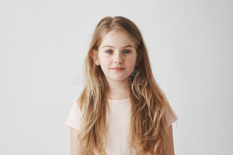 Slutet upp ståenden av den snygga unga flickan med blont hår i rosa färger klär och att se in camera med lugna uttryck arkivbild