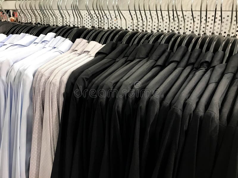 Slösa, gråna med den vita pricken och svärta skjortan på hängare i shopping royaltyfria bilder Slösa, gråna med den vita pricken och svärta skjortan på hängare i shopping royaltyfria bilder