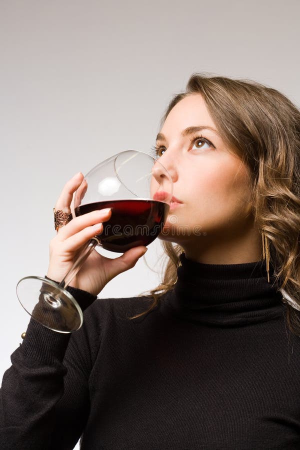 Gorgeous young brunette woman tasting dark red wine. Gorgeous young brunette woman tasting dark red wine.