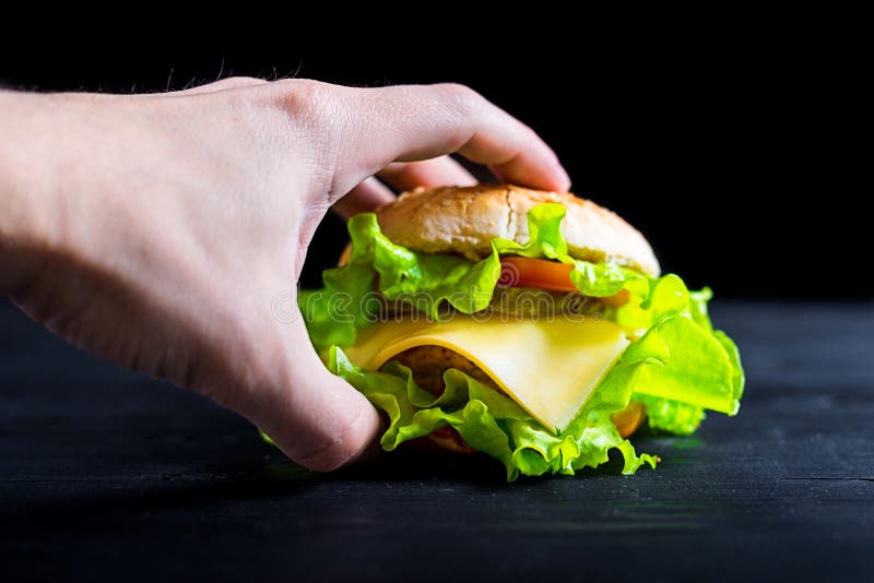 Smakelijke en verse hamburger op een houten zwarte lijst, reclamebanner royalty-vrije stock fotografie Smakelijke en verse hamburger op een houten zwarte lijst, reclamebanner royalty-vrije stock fotografie