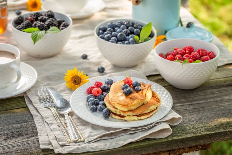 Smakelijke pannekoeken voor ontbijt in de zomertuin stock foto's Smakelijke pannekoeken voor ontbijt in de zomertuin stock foto's