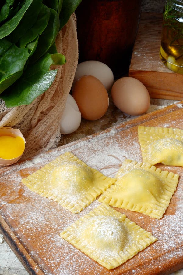 Smakelijke ruwe ravioli met ricotta en spinazie, met bloem en eieren op houten achtergrond Proces om Italiaanse ravioli te maken royalty-vrije stock foto's Smakelijke ruwe ravioli met ricotta en spinazie, met bloem en eieren op houten achtergrond Proces om Italiaanse ravioli te maken royalty-vrije stock foto's