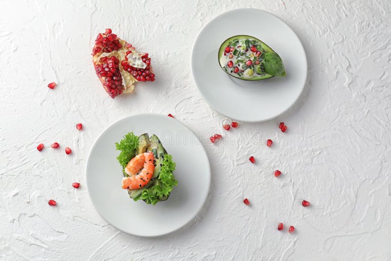 Smakelijke salades in avocadoboten op platen royalty-vrije stock fotografie Smakelijke salades in avocadoboten op platen royalty-vrije stock fotografie