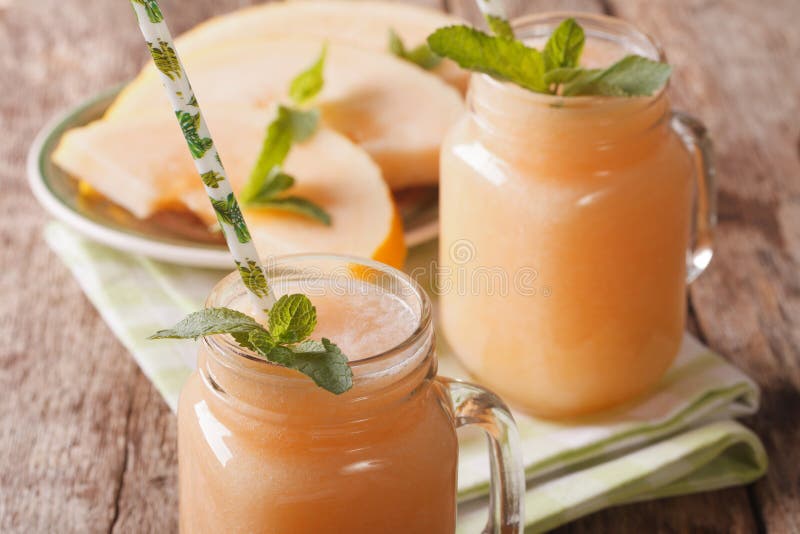Smakelijke smoothies van meloen met muntmacro in een glaskruik horizon stock afbeelding Smakelijke smoothies van meloen met muntmacro in een glaskruik horizon stock afbeelding