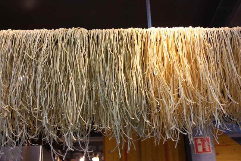 Smakelijke verse deegwaren met bundels zoals vers gemaakte en geknede spaghetti en op een rij geschikt op een te drogen draad royalty-vrije stock afbeeldingen Smakelijke verse deegwaren met bundels zoals vers gemaakte en geknede spaghetti en op een rij geschikt op een te drogen draad royalty-vrije stock afbeeldingen