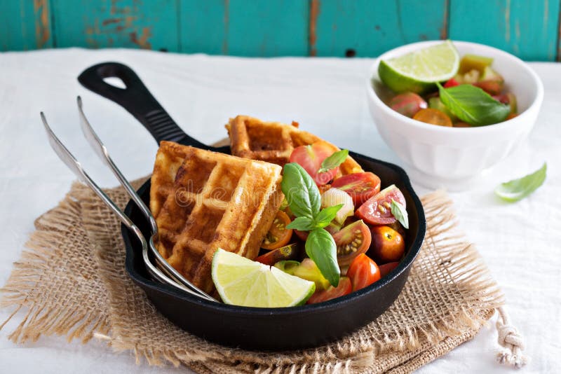 Savory waffles with cheese and cornmeal served with tomato salsa. Savory waffles with cheese and cornmeal served with tomato salsa