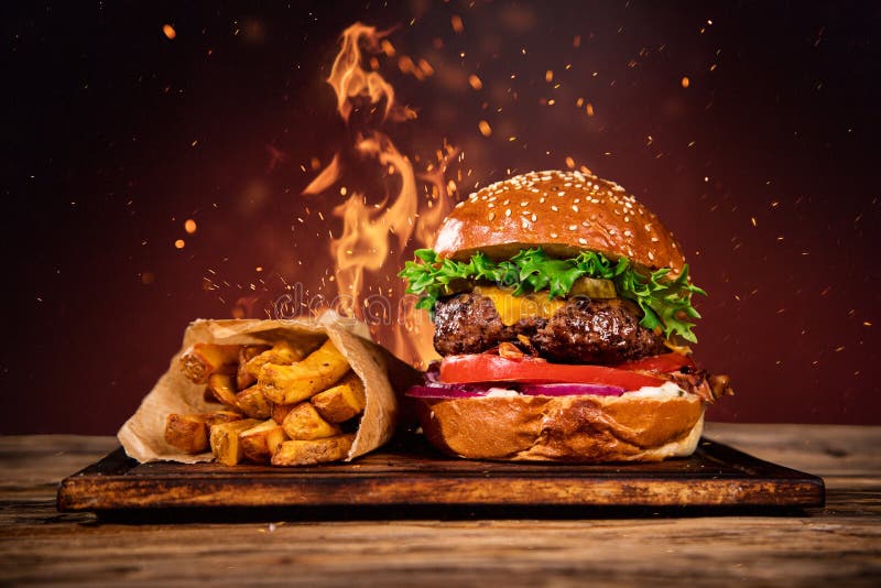 Close-up of home made tasty burger with french fries and fire flames. Close-up of home made tasty burger with french fries and fire flames.