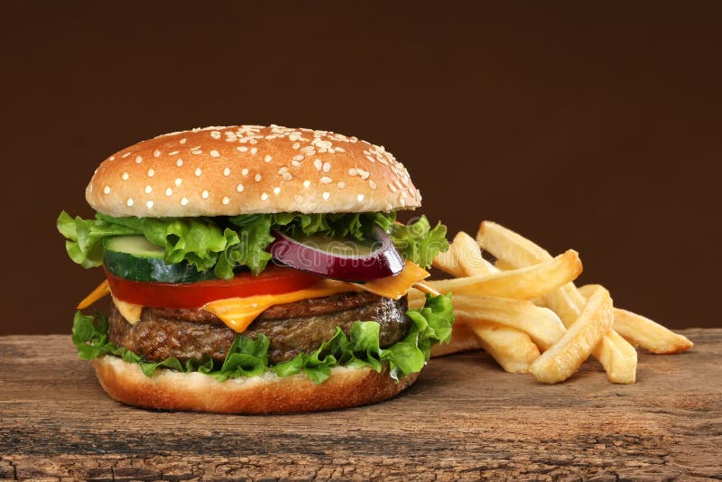 Tasty hamburger and french frites on wood background. Tasty hamburger and french frites on wood background.