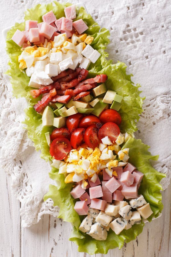 Smaklig närbild för amerikanCobb sallad på en platta på tabellen Vert arkivbild Smaklig närbild för amerikanCobb sallad på en platta på tabellen Vert arkivbild