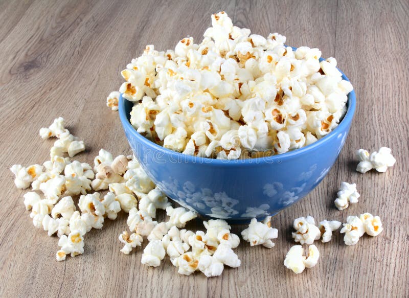 Tasty popcorn in the plate on wooden table. Tasty popcorn in the plate on wooden table