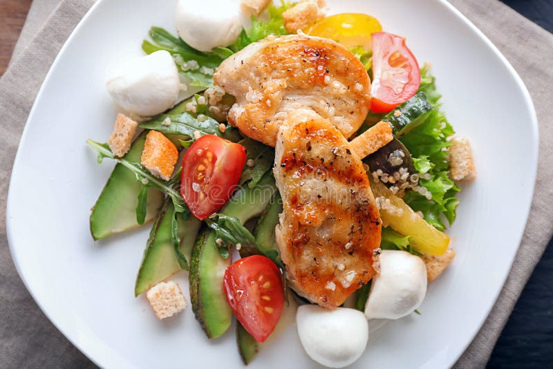 Smaklig sallad med höna, grönsaker och mozzarellaost på plattan, closeup arkivbild Smaklig sallad med höna, grönsaker och mozzarellaost på plattan, closeup arkivbild