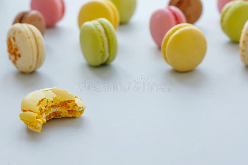 Smakowici gryźć koloru żółtego, menchii, zielonych i brown macarons na modnym pa obrazy royalty free