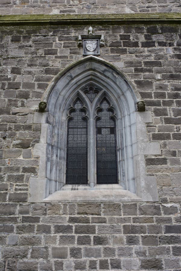 Small arched window on stone church wall