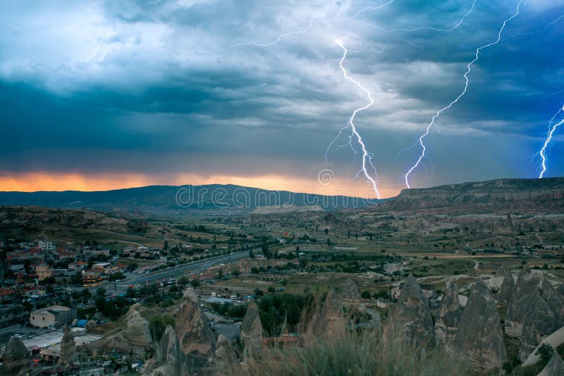 A small authentic city called Goreme in Cappadocia in Turkey. Dramatic night sky, sunset. Lightning above the town. Landscape, beautiful.