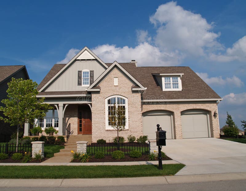 Small Beige  Brick Home  With Two Car Garage In Fron Stock 