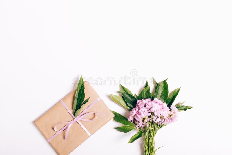 Small Bouquet of Pink Carnations and a Gift with Ribbon on White Stock ...