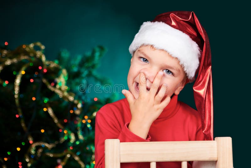 Small boy in santa hat picking nose