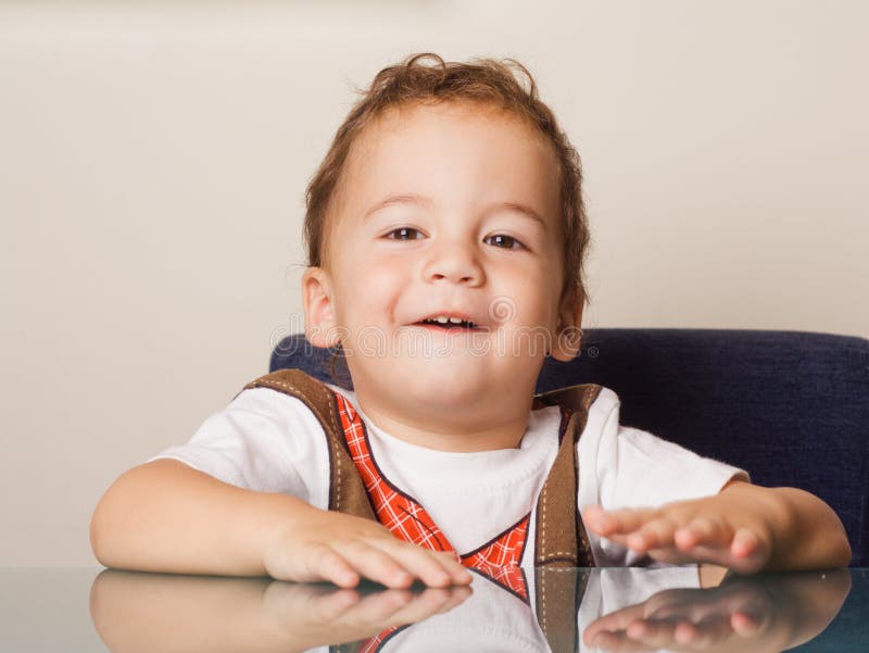 Small Boy Sitting At A Table Picture. Image 7716753