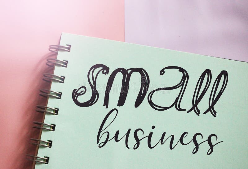 Small business words lettering on mint color page in copybook on pink. Business startup idea concept