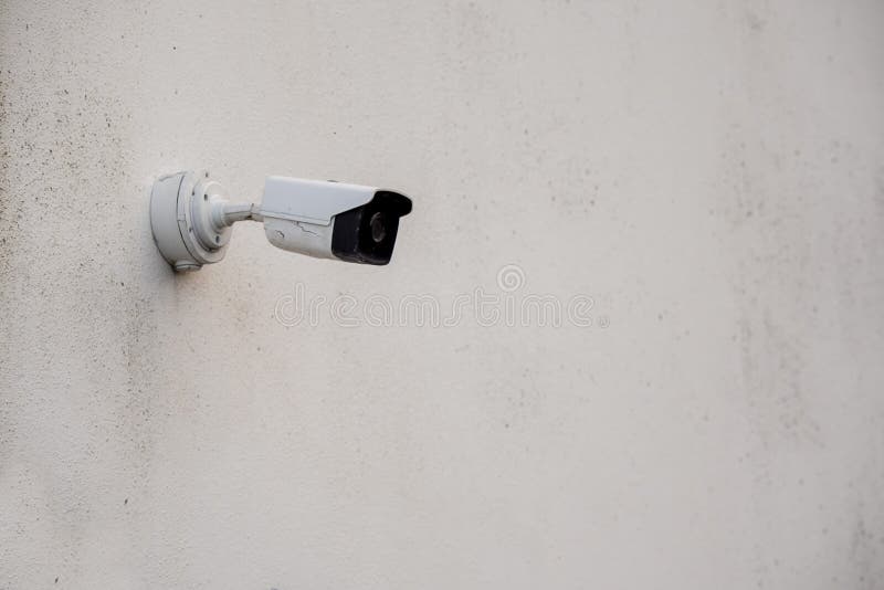 Small CCTV Surveillance Camera on a Light Color Wall. Security Industry, Copy Space Stock Photo