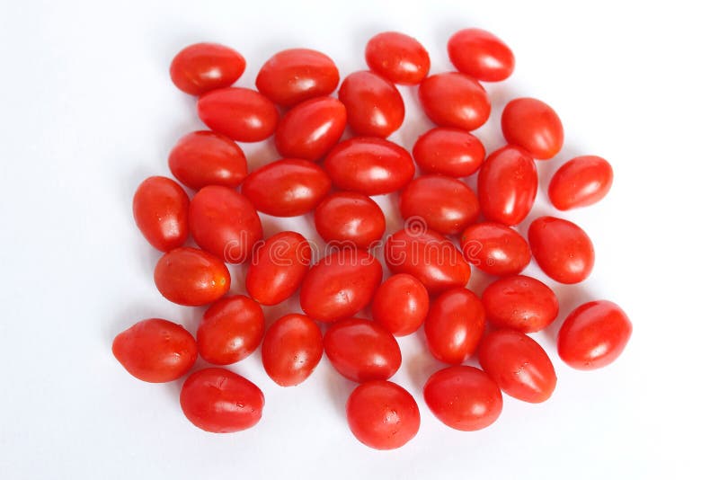 Small cherry tomatoes long red and fresh in group on white background