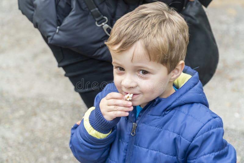 Small Child Eating Popcorn in a Park Stock Photo Image of blue