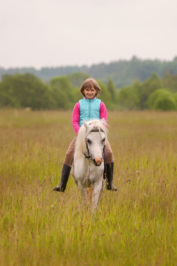 Small child riding on a white horse and smiling Outdoors royalty free stock photos Small child riding on a white horse and smiling Outdoors royalty free stock photos