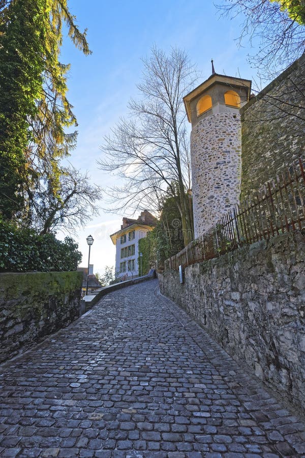 Small Cobblestone paved road in the Old City of Thun. Thun is a city in Swiss canton of Bern, where Aare river flows out of Lake Thun. Town Hall Square is a historic center of the city