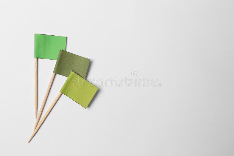Small color paper flags on light background, flat lay. Space for text royalty free stock photos