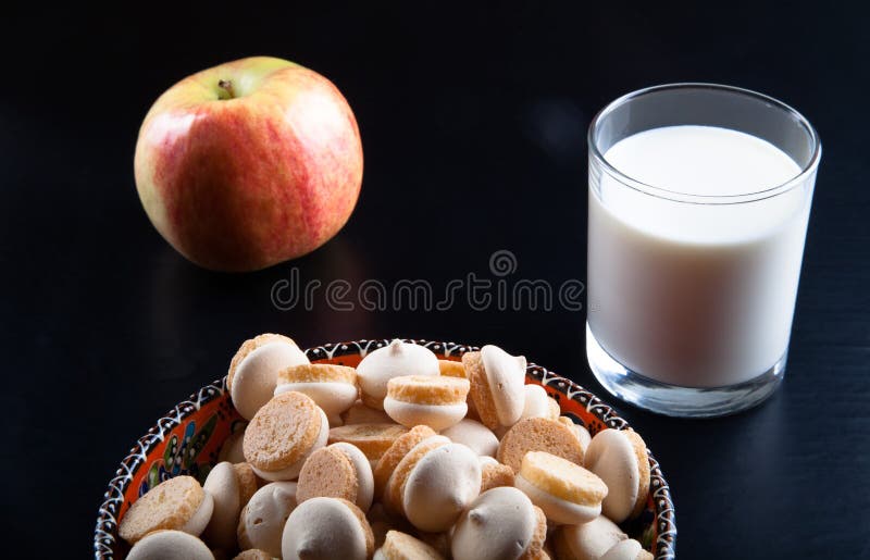 Small cookies in the Turkish bowl, apple and glass of milk on a