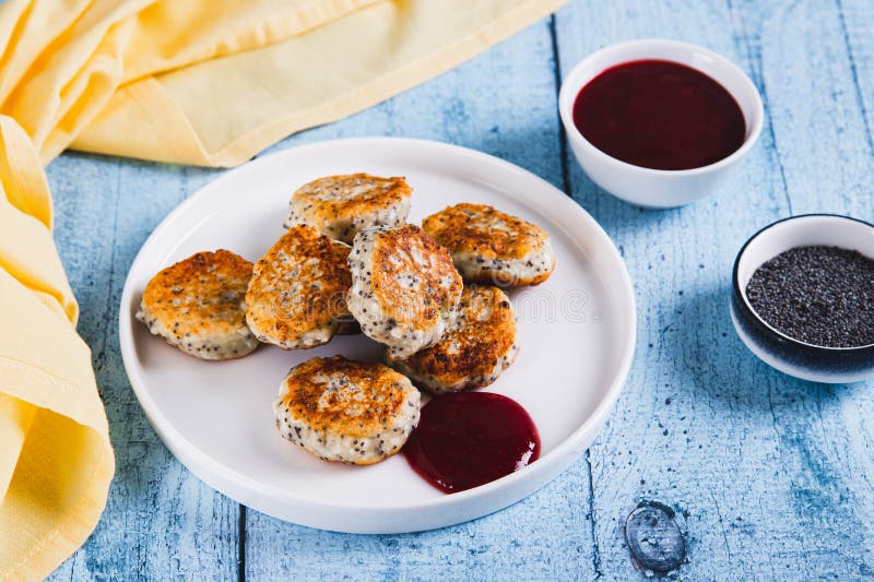 Small cottage cheese pancakes with poppy seeds on a plate on the table royalty free stock image
