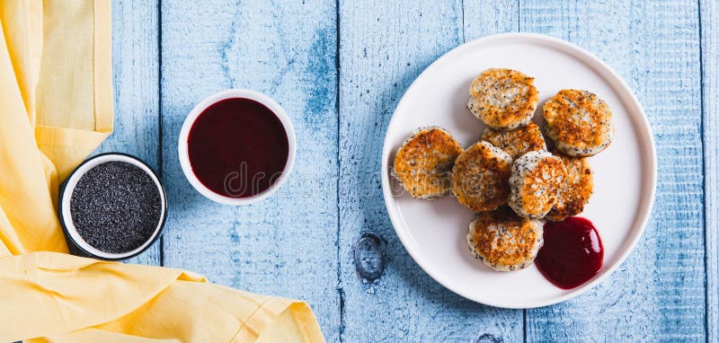Small cottage cheese pancakes with poppy seeds on a plate on the table top and web banner stock photo