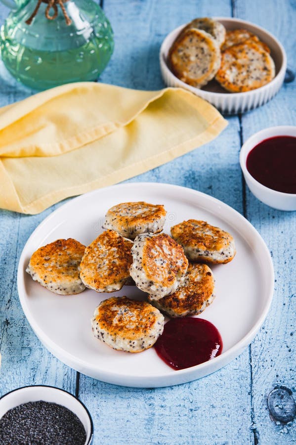 Small cottage cheese pancakes with poppy seeds on a plate on the table vertical view royalty free stock photos